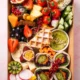 Vegetarische Brunch Box aus Wien mit frischem Obst, Hummus, Falafel-Wraps, Avocado, Waffel, Käse und Gemüsesticks – ideal für gesunden Brunch oder Catering.