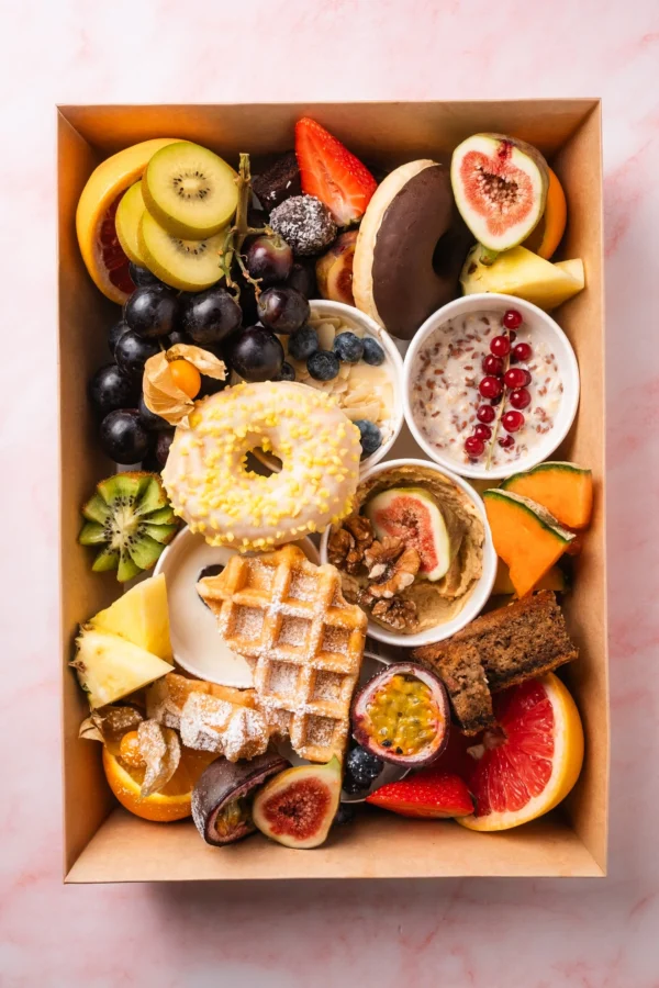 Vegetarische süße Brunch Box aus Wien mit Donuts, Waffeln, Müsli, frischem Obst, Nüssen und Aufstrichen – perfekt für Frühstück, Brunch oder Geschenkideen.