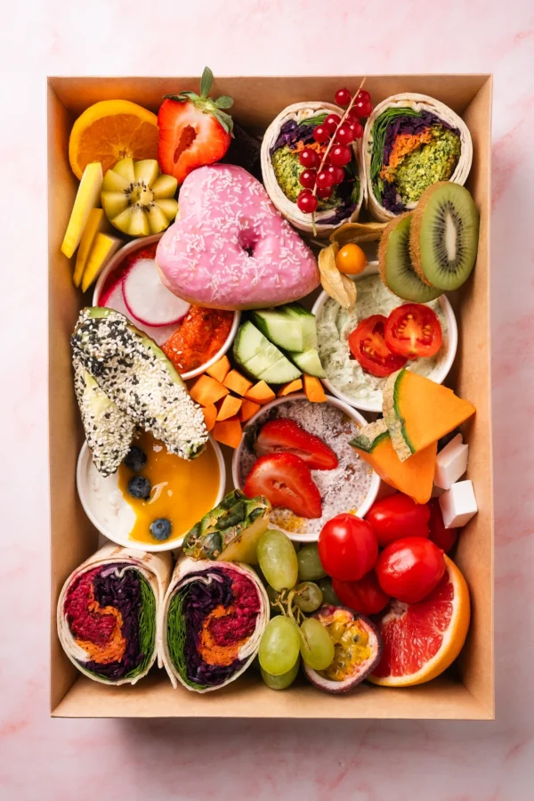 Vegane Brunch Box aus Wien mit frischem Obst, Gemüse, Wraps, pflanzlichen Aufstrichen, Avocado und Chia-Pudding – rein pflanzlich, ausgewogen und bunt zusammengestellt.