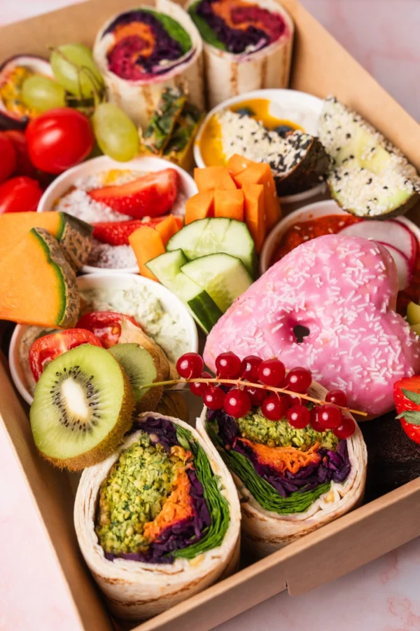 Vegane Brunch Box aus Wien mit frischem Obst, Gemüse, Wraps, pflanzlichen Aufstrichen, Avocado und Chia-Pudding – rein pflanzlich, ausgewogen und bunt zusammengestellt.
